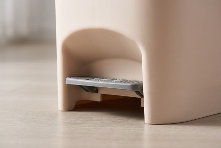 Close-up of the foot pedal on a plastic trash bin with pedal.